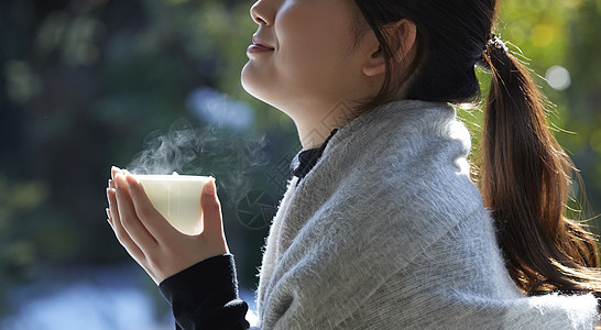 年轻女孩秋冬保暖捧着热茶图片