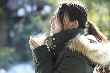 年轻女孩秋冬保暖捧着热茶图片