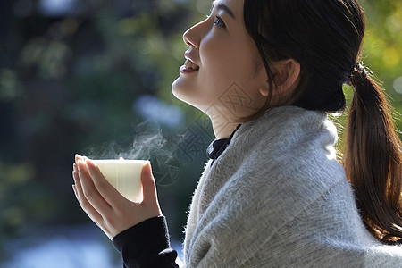 年轻女孩秋冬保暖捧着热茶图片