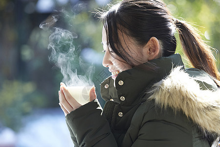 年轻女孩秋冬保暖捧着热茶图片