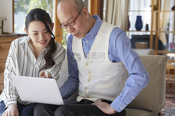 年轻女孩教老人使用笔记本电脑图片