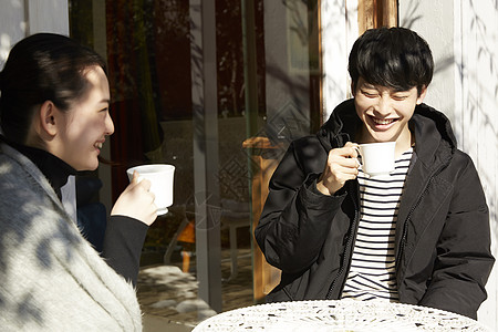 年轻男女屋外晒太阳聊天喝茶图片素材