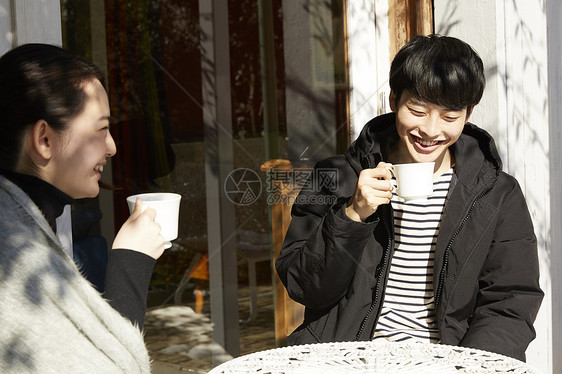 年轻男女屋外晒太阳聊天喝茶图片