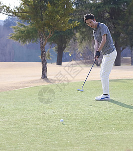 在户外打高尔夫球的男性图片