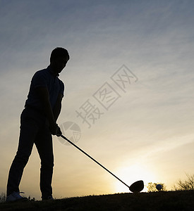夕阳下打高尔夫球的人图片