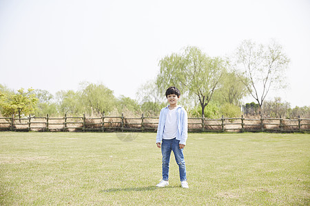 春天站在草坪上的小男孩图片