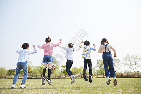草坪上跳跃的孩子们背影图片
