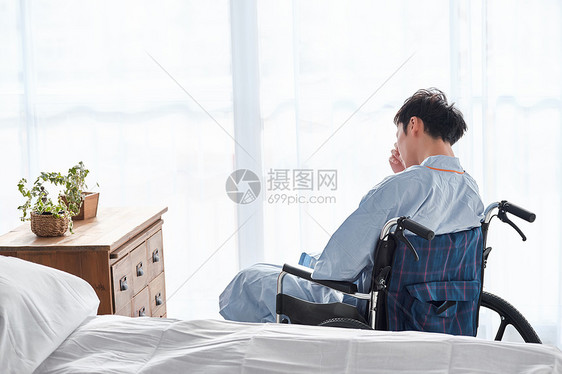 凌乱起居室思考坐在轮椅上的男人图片