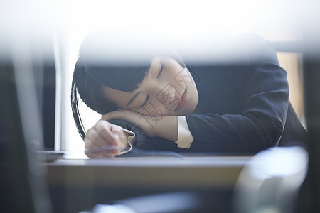 趴在桌上休息的商务女性图片