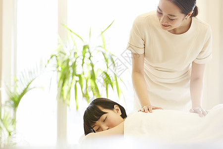 女性spa技师为顾客背部按摩图片素材