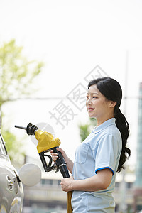 加油站兼职拿着加油枪的青年女性背景图片