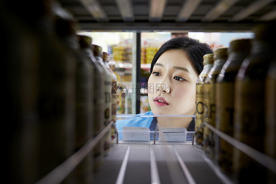 便利店女职员在整理货架商品图片