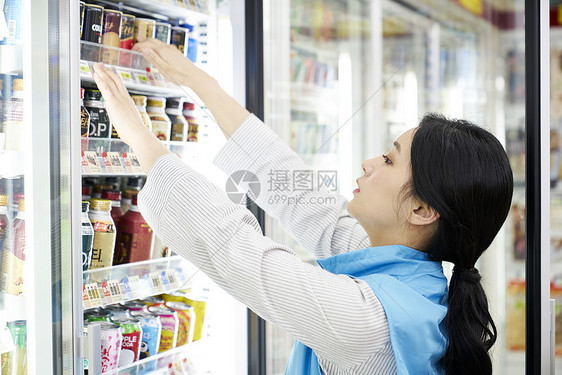 便利店女职员在检查货架商品图片