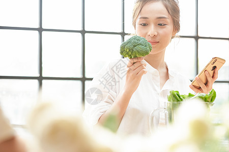 拿着西兰花的年轻女子图片