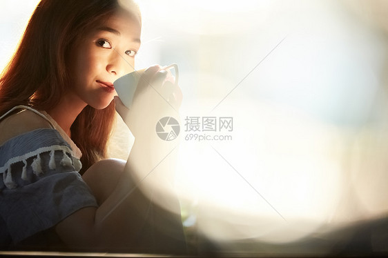 喝咖啡微笑的年轻女子图片
