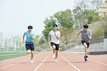 三个青年在跑道上赛跑图片