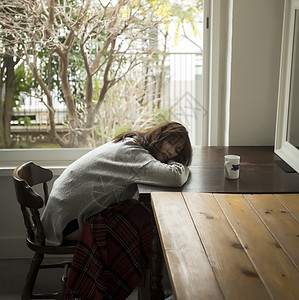 懒惰的女生坐在椅子上的女人趴桌上休息背景