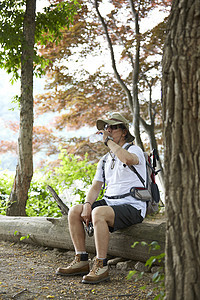 登山休息喝水的背包客图片