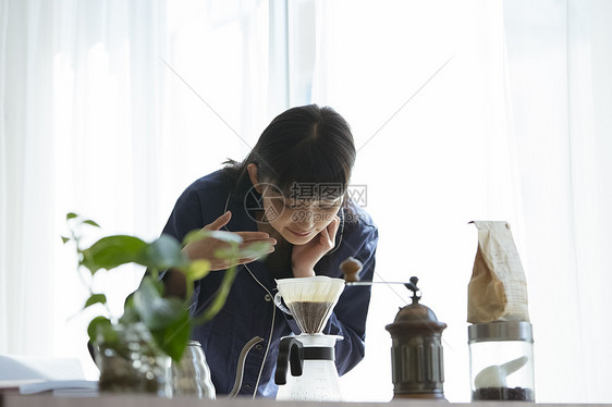 泡咖啡闻的年轻女子图片