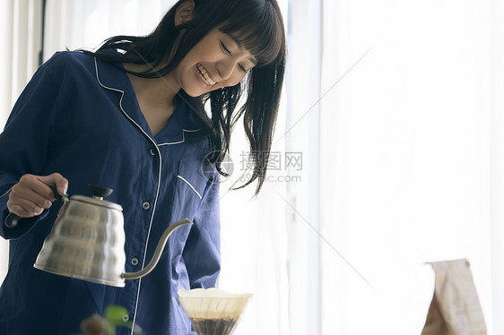 冲泡咖啡微笑的年轻女子图片