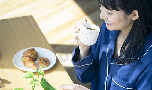 早餐喝咖啡的年轻女子图片