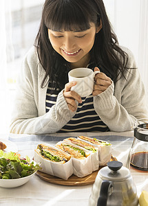 年轻女子低头看着餐桌的食物图片