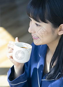 年轻女子微笑的喝咖啡图片
