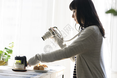 年轻女子拍摄食物照片图片