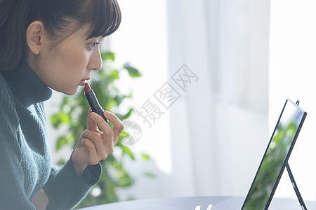 涂抹口红化妆的年轻女子图片