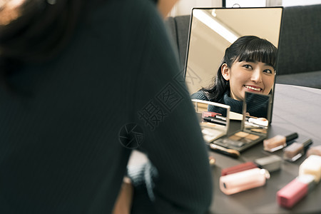 镜子里笑容灿烂的年轻女子图片