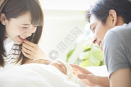 年轻夫妇在照看初生婴儿图片