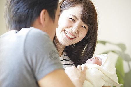 年轻夫妇在照看初生婴儿图片