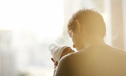 背影阳光爸爸抱着婴儿抚养孩子图片