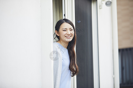 靠在窗边的居家女性图片