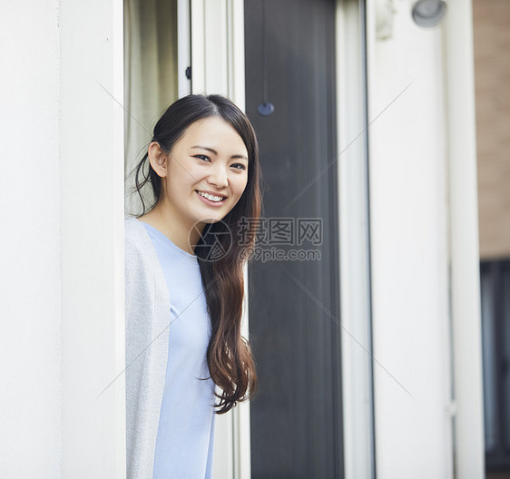 靠在窗边的居家女性图片