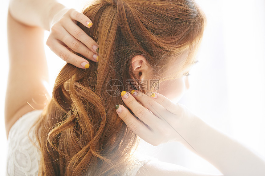 整理发型的女性背影图片