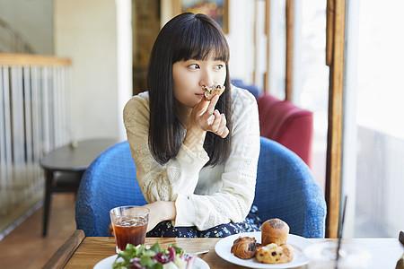 咖啡馆吃下午茶的年轻女子图片