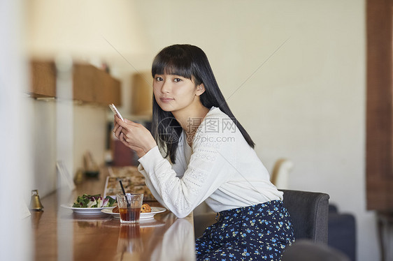 拿着手机微笑的年轻女子图片