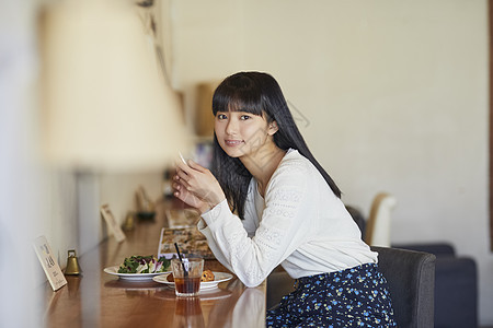 年轻女子在咖啡馆吃下午茶图片