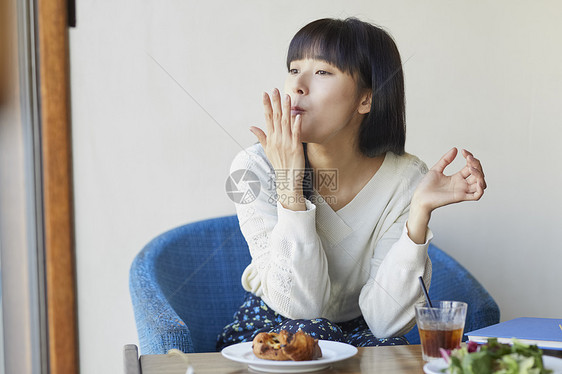 年轻女子在咖啡馆吃下午茶图片