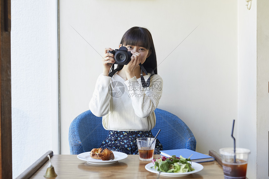 年轻女人拿着相机图片