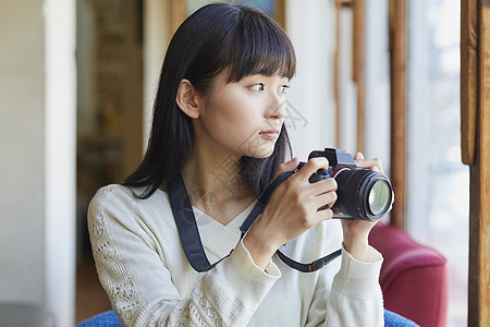 年轻女人拿着相机图片