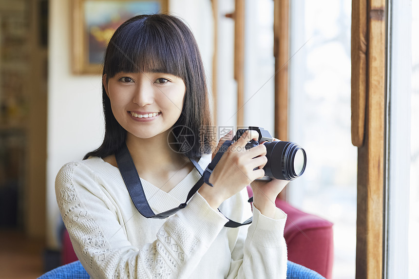 年轻女人拿着相机图片