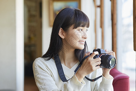 年轻女人拿着相机图片