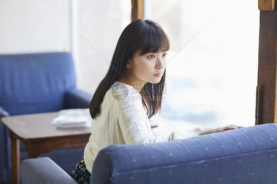 年轻女人坐在沙发上图片