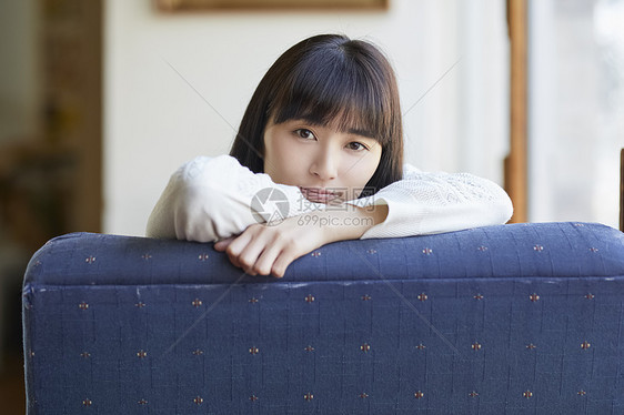 年轻女人趴在沙发椅背上图片