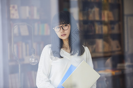 学生透过镜片走在这个城市一家书店的女人图片