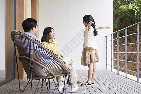 父母和女儿在阳台上休息图片