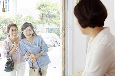 中年女性隔着橱窗观望图片