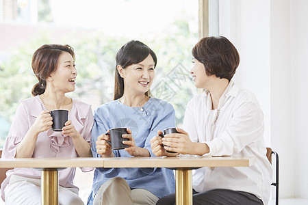 成年女子和伙伴在咖啡店享受下午茶图片